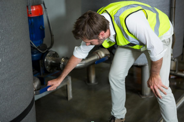 a man in a safety vest inspecting a gas pipe